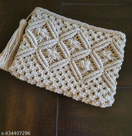Handmade cream macrame clutch with tassel, textured fabric, one main compartment, zip closure, size: 20cm x 30cm. Colourful accessory for beach or casual outings, perfect for essentials storage. Made in India by skilled artisans