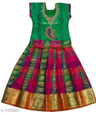 Traditional green art silk pattu pavadai lehenga for baby girls, solid pattern Indian attire on display