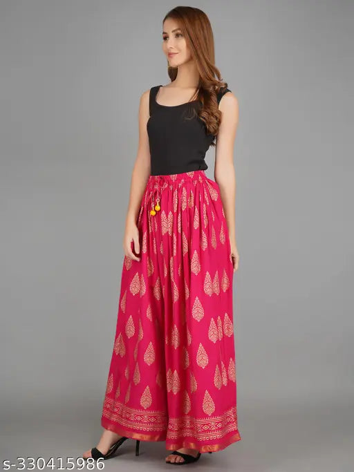 Pink rayon flared skirt with gold print, elastic waistband, and full length. Traditional Rajasthani Jaipuri ethnic design for women's fashion. Maximum comfort and silky feel. Available in multiple sizes (26-XXL), made in India