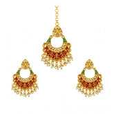 Rose gold plated alloy Kundan earrings & Mangtikka in red and green, ornamental Indian jewelry on display