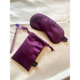 Purple solid satin silk eyemask for everyday use, unisex comfort on bedside table