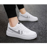 White synthetic lace-up sneakers, solid pattern for men's casual wear on display