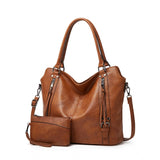 Brown PU leather large shoulder zipper handbag for women, featuring round twin handles and adjustable sling strap