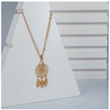 Gold-plated stainless steel dream catcher pendant on delicate chain, captivating detail