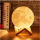 Multi-colored plastic 3D moon night lamp on nightstand, decorative home accent item for bedroom or office space