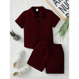 Maroon popcorn patterned boys' shirt-short set, solid short sleeves on playful model