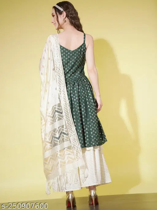 A woman in a dress, standing against a yellow background; holding a long, beige dupatta with intricate patterns and designs