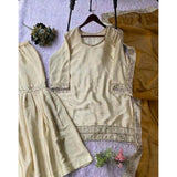 Cream & yellow silk embroidered 3/4th sleeve V-neck kurti set with sharara pant and dupatta, traditional Indian women's wear on display