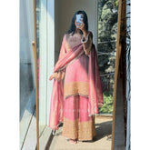 Pink silk embroidered 3/4th sleeve round kurti set with sharara pant and dupatta, calf length, on mannequin