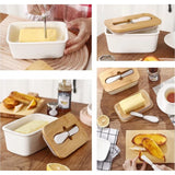 { "alt_text": "White ceramic butter box with bamboo lid, airtight storage container for fresh butter, kitchen countertop accessory" }