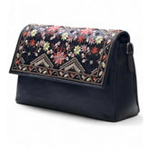 { "alt_text": "Black polyurethane crossbody sling bag with floral embroidery, adjustable strap, women's fashion accessory" }