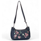 { "alt_text": "Black polyurethane crossbody sling bag with floral embroidery, adjustable strap, women's fashion accessory" }