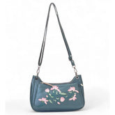 { "alt_text": "Light blue polyurethane crossbody sling bag, floral embroidered women's bag, adjustable strap, fashion accessory" }