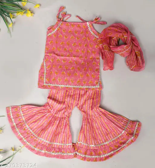 Red cotton printed kurti sharara set for baby girls with dupatta, featuring Anarkali top and elasticized sharara bottom. Ethnic look with gota patti and dori details, suitable for Indian festivals like Diwali, Janmashtami, and Rakhi. Sizes available from 6-12 months to 5-6 years. Handcrafted in India