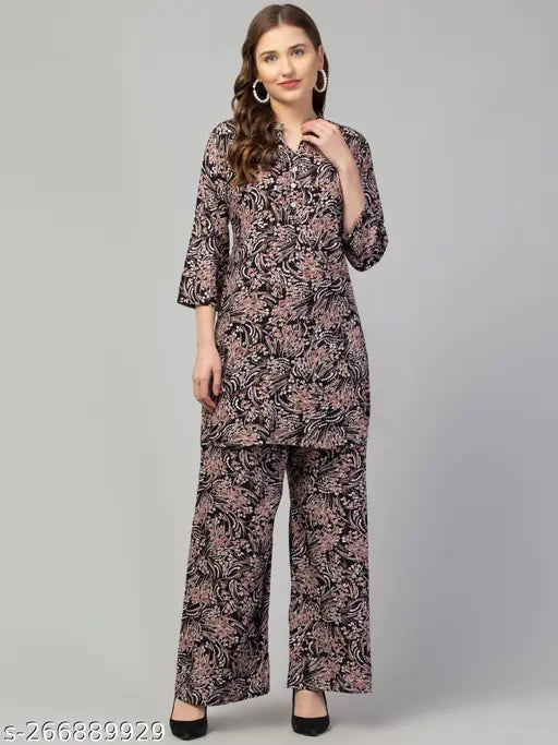 Black multi printed rayon top with palazzo set for women, featuring three-quarter sleeves and a printed design reminiscent of a woman's dress. Suitable for various occasions, machine washable, and available in multiple sizes (M, L, XL) and colors. Indian craftsmanship