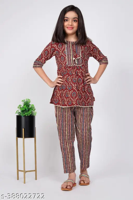 Embroidered cotton girls kurta and pant set in printed net, three-quarter sleeves, sizes range from 8-9 years to 13-14 years. Indian traditional clothing for girls on display