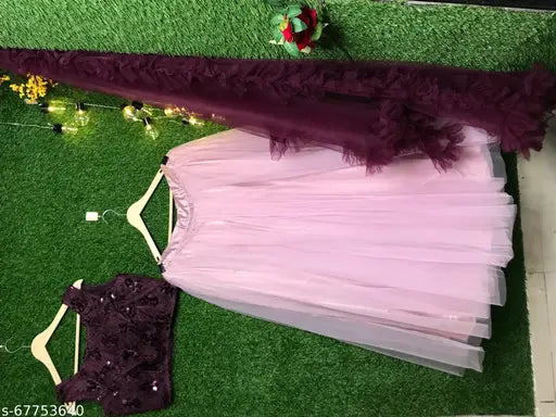 Pink jute silk net chaniya choli with wine blouse, embellished top on display. Semi-stitched Indian bridal lehenga set for weddings, parties." (105 characters)