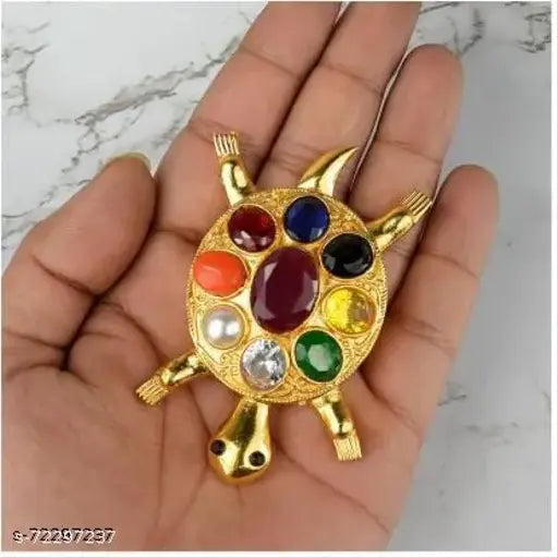 Gold-polished brass Feng Shui Kachua Tortoise figurine with Navratna gemstones, for good luck office decor. Each gemstone represents a planet: Ruby, Pearl, Red Coral, Emerald, Yellow Sapphire, Diamond, Blue Sapphire, Hessonite, Cat's Eye. Handmade, unique piece. Place in home back area or entrance for energy stabilization, near water features or north sector for career. Made in India