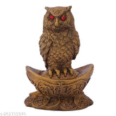 Synthetic resin owl statue sitting on gold Yuan Bao, popular Feng Shui symbol for attracting wealth and good luck in Indian home decor