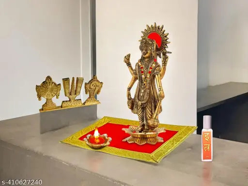 Red velvet carpet Chaturbahu Vishnu figurine, golden diya oil lamp, and moti mala on Pooja Aasan deity ornament for religious worship. Premium aluminum handicraft