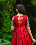 Banarasi silk short-sleeved women's gown, richly patterned with zari woven net on a traditional Indian floor