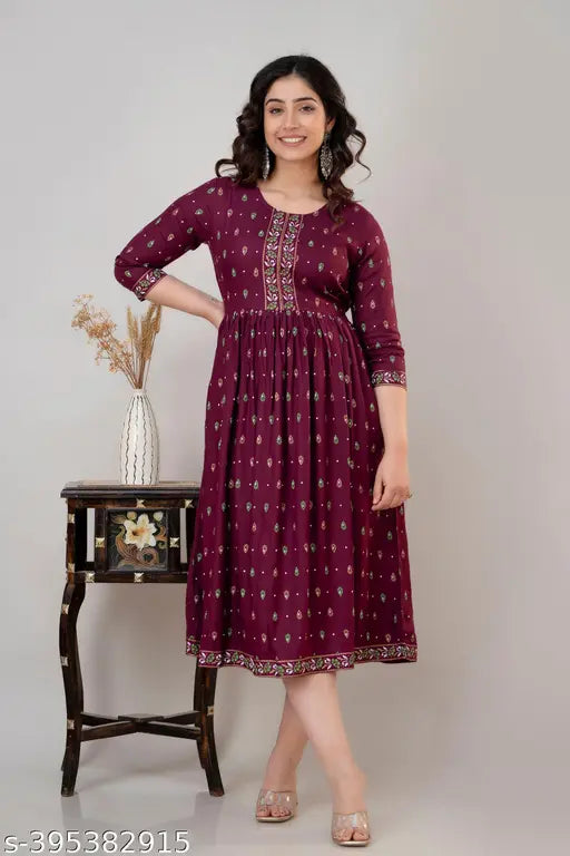 Rayon-cotton women's printed Anarkali Kurta in wine or Firozi color, three-quarter sleeves, formal and casual wear. Printed combo with round neckline and calf length. Includes one kurta. Breathable fabric for comfort in warmer weather. Made in India