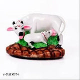 Handcrafted poly resin mother cow with calf, adorned with red and green clothes and stones. Multicolored animal figurine, perfect for home temples or showpiece shelves. Made by JMK Enterprises, from India