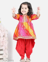 Stylish red bandhej kurta & dhoti set with cotton rayon fabric, A-line silhouette, and three-quarter sleeves. Bandhani & lace embellished Indian women's fashion for girls aged 1-8 years