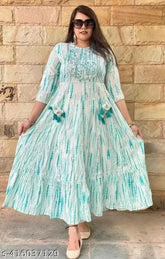 Green embellished festival gown from Maheen Exports, featuring a tie-dye printed design on rayon fabric with three-quarter sleeves. Available in sizes S-XXXL. Perfect for parties, weddings, and festive occasions