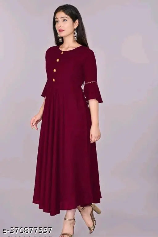 Maroon rayon flared kurti, three-quarter sleeves for women's casual or formal wear. Single-color design, hand wash/machine washable. Size declaration: choose two inches larger than body measurement