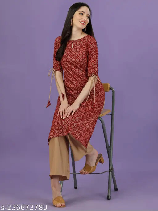 Maroon rayon kurta and palazzo set with all-over gold print, keyhole neck, three-quarter sleeves, tie-up and tassels. Indian ethnic wear for women