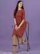Maroon rayon kurta and palazzo set with all-over gold print, keyhole neck, three-quarter sleeves, tie-up and tassels. Indian ethnic wear for women