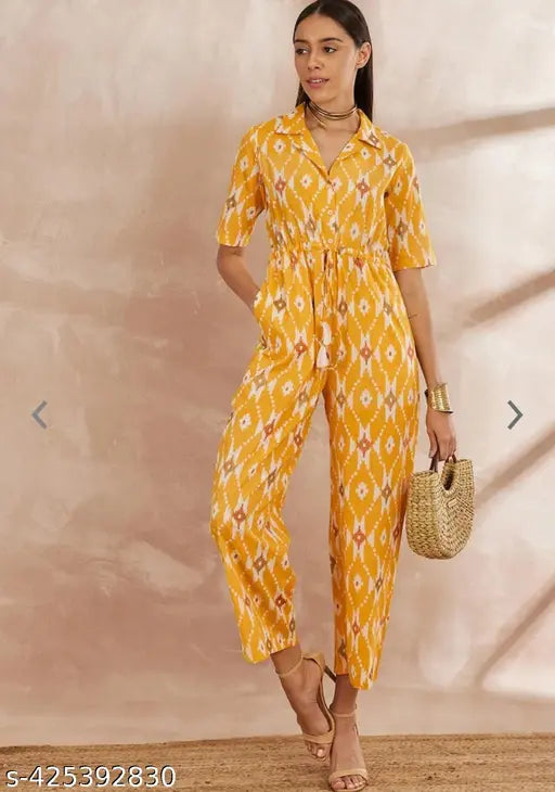 Yellow rayon printed jumpsuit on mannequin, featuring short sleeves and vibrant design. XS (34in bust, 52in length, 32in waist, 36in hip), S (36in bust, 52in length, 34in waist, 38in hip), M (38in bust, 52in length, 36in waist, 42in hip), L (40in bust, 52in length, 38in waist, 43in hip), XL (42in bust, 52in length, 40in waist, 45in hip), XXL (44in bust, 52in length, 42in waist, 47in hip). Made in India