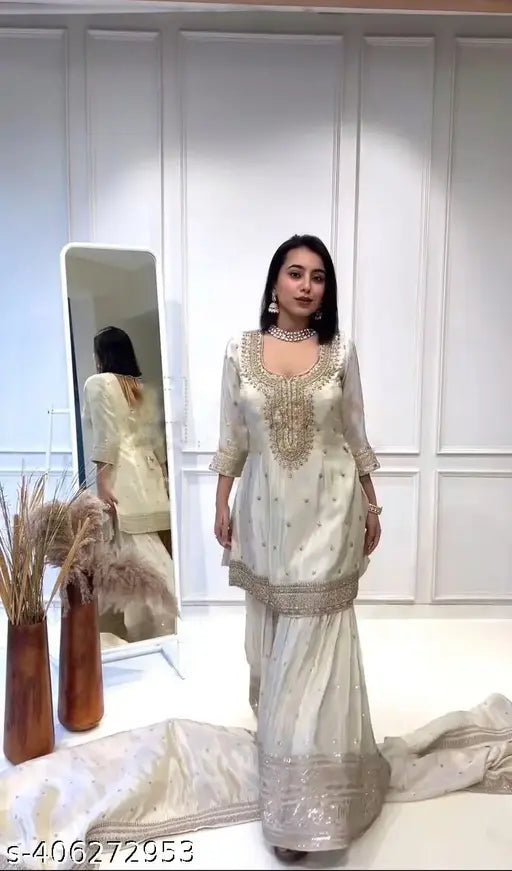 White Chinon silk kurti replica with embroidered three-quarter sleeves, dupatta, and bottomwear. Pure Chinnon silk gharara with elastic, and lace border on dupatta. Ready-to-wear Indian outfit