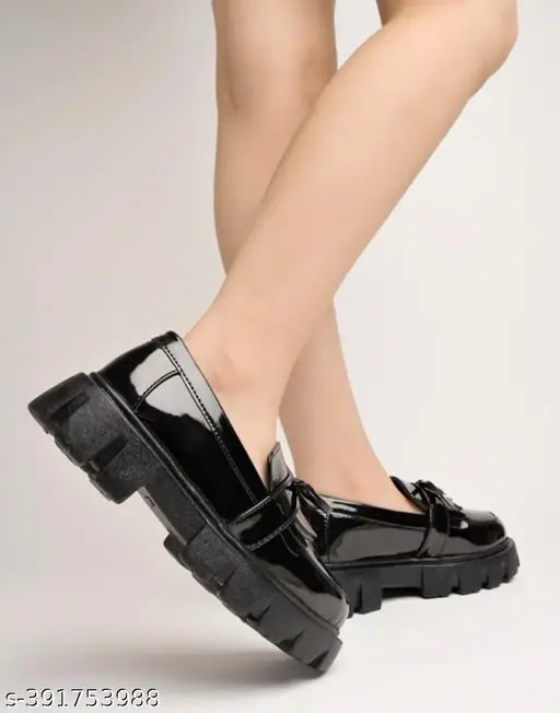 Black patent leather loafers for girls, detailed chain design, smart casual footwear on display