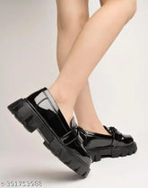 Black patent leather loafers for girls, detailed chain design - casual footwear accessory on display stand