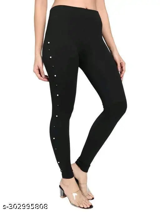 Solid black poly-cotton stretch jegging for women and girls, featuring side stones and a regular fit. Super soft fabric with elasticized waistband, suitable for casual wear or Indian outfits. Available in sizes 28 (26 waist, 37 length), 30 (28 waist, 37 length), 32 (30 waist, 37 length). Made in India
