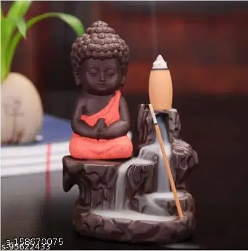 Handcrafted monk orange poly resin Buddha smoke backflow cone incense holder, includes 10 incense cones. Artistic home decor item featuring reverse smoke flow illusion beside meditating Buddha figure