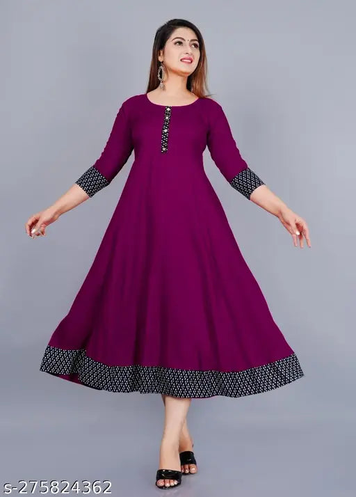 Purple rayon round flared kurti with three-quarter sleeves, solid print design. Hand wash or machine wash. Size ranges from XS to XXXL. Perfect for casual and formal occasions. Made in India
