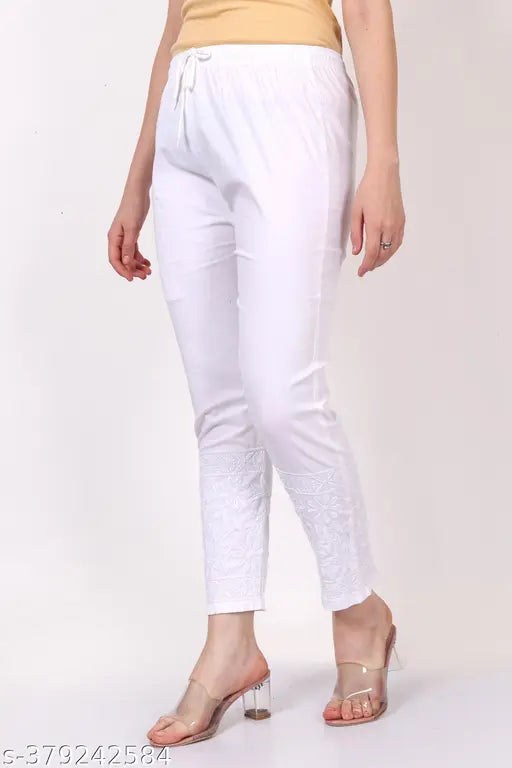 White cotton lycra pant with floral computer embroidery, elastic waistband with drawstrings and single pocket. Made in India