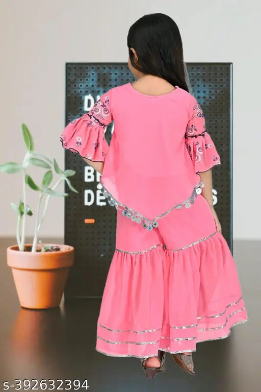 Pink cotton blend sharara kids dress set with anarkali top and sharara bottom, embellished three-quarter sleeves. Suitable for girls aged 4-12 years. Indian origin