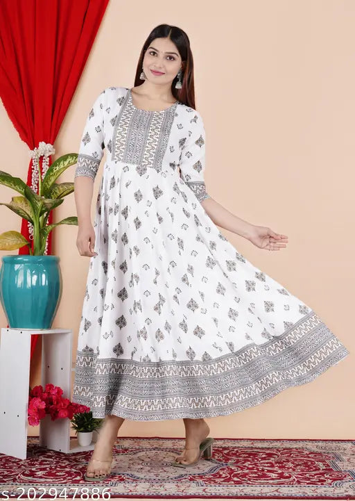 White rayon anarkali border print kurti with tassels, perfect for casual and semi-formal occasions. Ankle length, three-quarter sleeves, and round neckline. Made in India