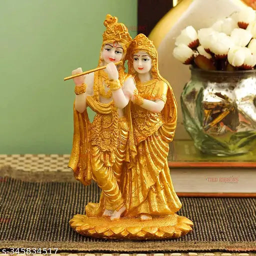 Resin Radha Krishna statue sculpture with gold plating, diya, black tray, and multi-colored stones. Ideal for home decor, living room, or temple use. Indian origin