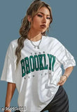 White cotton printed oversize Brooklyn t-shirt with off-shoulder design for women, featuring a trendy motif on a short sleeve. XS (36in bust, 25in length), S (38in bust, 26in length), M (40in bust, 27in length), L (42in bust, 28in length), XL (44in bust, 29in length) also available in black