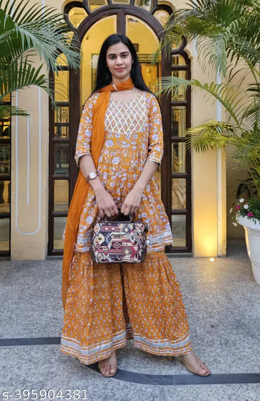 Mustard rayon kurta sharara set, three-quarter sleeves, printed with stitched net detail. India-made mustard kurta and bottomwear set for women