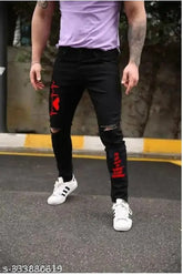 Red denim knee-cut printed jeans, placement print detail on display