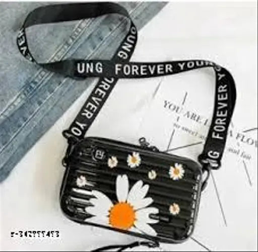 Acrylic floral print black sling bag, detachable shoulder strap for women. Polycarbonate hard shell interior with two zippered pockets and compact space for organizing essentials. Lightweight, portable design ideal for travel. Indian origin