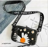 Acrylic floral print black sling bag, detachable shoulder strap for women. Polycarbonate hard shell interior with two zippered pockets and compact space for organizing essentials. Lightweight, portable design ideal for travel. Indian origin