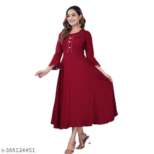 Maroon rayon women's anarkali flared kurti with three-quarter sleeves, solid design. Close-up of fashionable Indian attire