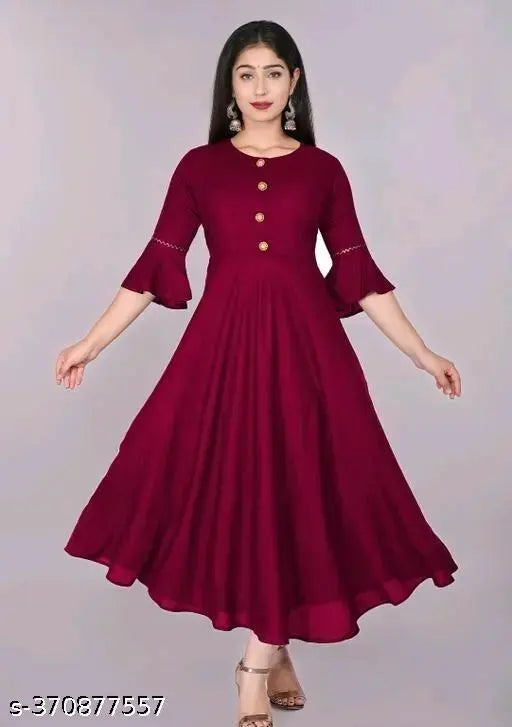 Maroon rayon solid flared kurti with three-quarter sleeves, hand wash or machine wash, suitable for casual and formal occasions, size declaration: choose two inches larger than body measurement. Made in India
